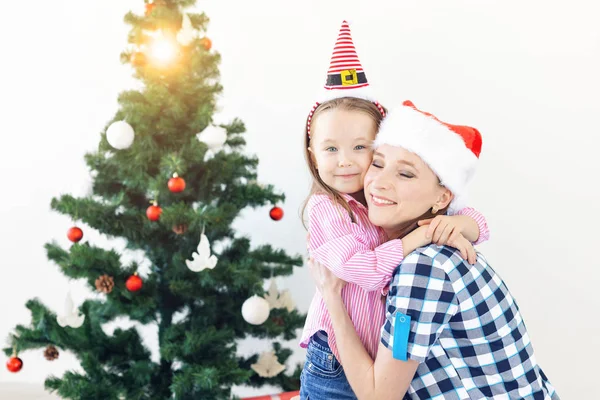 Koncepcja świąt Bożego Narodzenia, rodziny i świąt - Uroczysta matka i córka na kanapie w domu w salonie — Zdjęcie stockowe