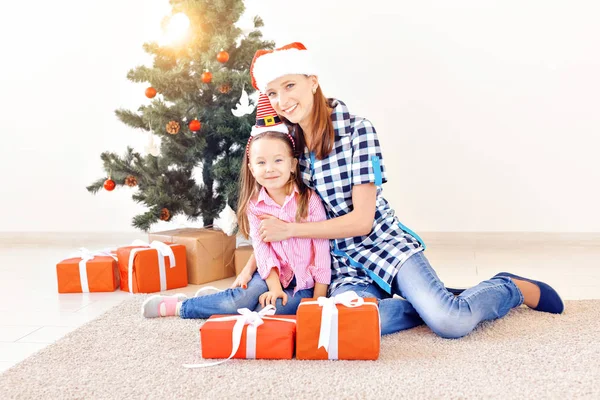 クリスマス、家族と休日のコンセプト-リビングルームの自宅でソファの上の祭りの母親と娘 — ストック写真