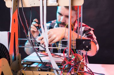 Erkek öğrenci ürünü 3D yazıcıda yapıyor