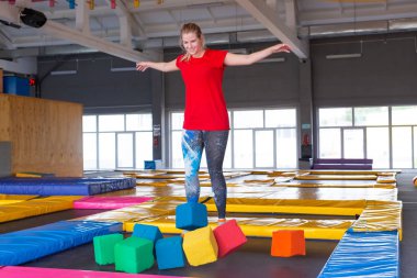 Fitness, eğlence, eğlence ve spor aktivite konsepti - Genç mutlu kadın kapalı bir trambolin üzerinde atlama