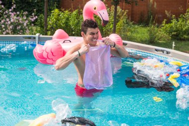 Ekoloji, plastik çöp, çevresel acil durum ve su kirliliği - kirli bir yüzme havuzunda duran şok adam