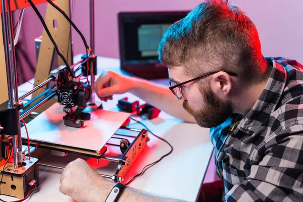年轻的男性设计师工程师在实验室使用3D打印机，研究产品原型、技术和创新概念 — 图库照片