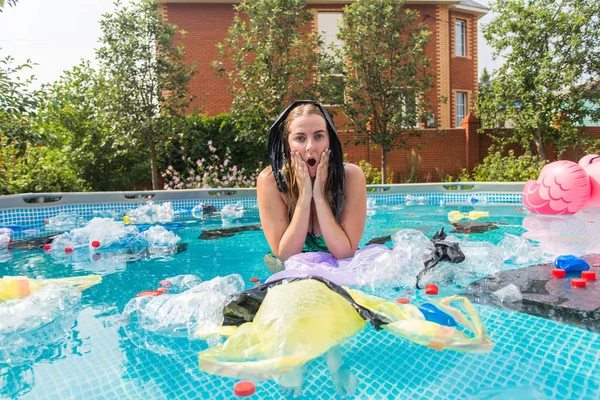 Ecologie, plastic afval, milieu noodsituatie en watervervuiling - Schreeuwende vrouw met een plastic zak over zijn hoofd in een vies zwembad — Stockfoto