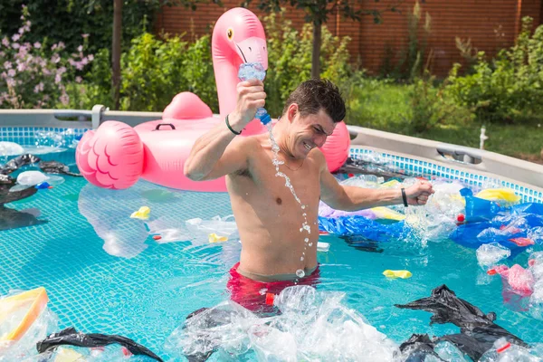 Ecologie, plastic afval, milieuramp en watervervuiling - geschokte man in een vies zwembad — Stockfoto