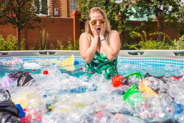 Ecology, plastic trash, environmental emergency and water pollution - Shocked woman in a dirty swimming pool