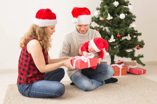 Happy couple with baby celebrating Christmas together at home. — Stock Photo, Image