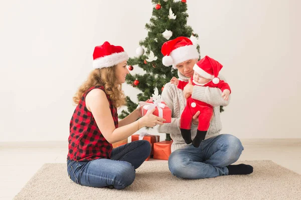 Otec s jeho chlapeček nosí Santa klobouky slaví Vánoce. — Stock fotografie
