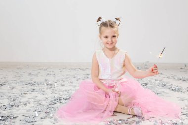 Tatiller, Noel, doğum günü partisi ve yeni yıl konsepti, elinde yanan maytap tutan çocuk. Komik bir partiden sonra.