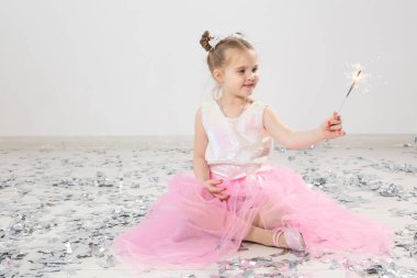 Tatiller, Noel, doğum günü partisi ve yeni yıl konsepti, elinde yanan maytap tutan çocuk. Komik bir partiden sonra.