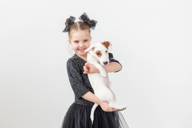 Evcil hayvan ve hayvan kavramı - Jack Russell Terrier köpekle oynayan kız çocuk.