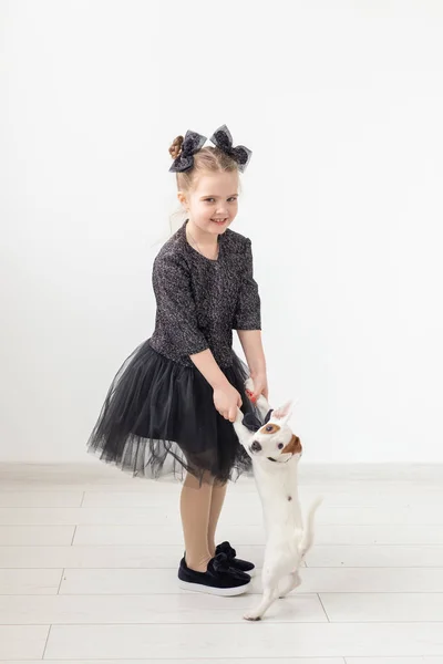 Husdjur och djur koncept - barn flicka som leker med valp Jack Russell Terrier. — Stockfoto