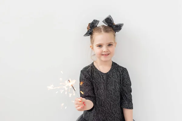 Semester, jul och nyårskoncept - Lyckligt barn håller brinnande tomtebloss i handen över vit bakgrund med kopieringsutrymme — Stockfoto