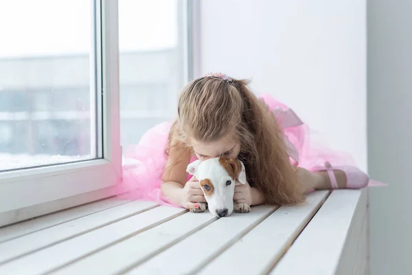 Djur och barn koncept - Barn med hund Jack Russell Terrier hemma — Stockfoto