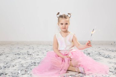 Tatiller, Noel, doğum günü partisi ve yeni yıl konsepti, elinde yanan maytap tutan çocuk. Komik bir partiden sonra.