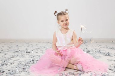 Tatiller, Noel, doğum günü partisi ve yeni yıl konsepti, elinde yanan maytap tutan çocuk. Komik bir partiden sonra.