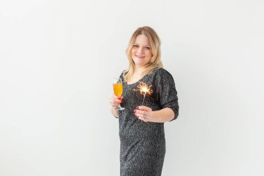 Tatiller, Noel, doğum günü ve yeni yıl konsepti - Kadın şarabı bir bardakta ve beyaz arka planda, kopyalama alanı ile maytap üzerinde kutluyor ve tutuyor