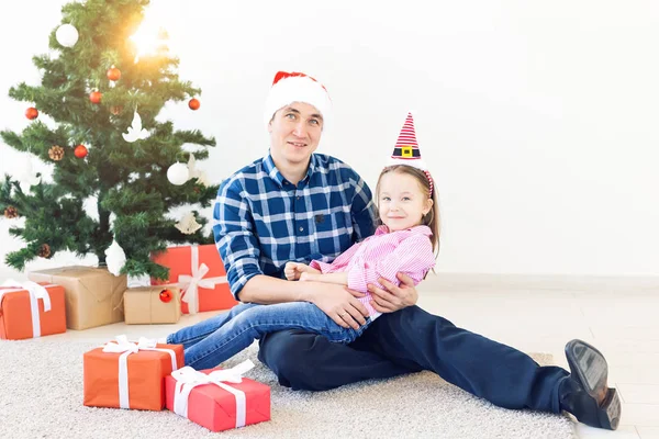 Dovolená, Vánoce, rodina a štěstí koncept - legrační otec a dcera u vánočního stromku — Stock fotografie