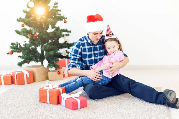 Dovolená, Vánoce, rodina a štěstí koncept - legrační otec a dcera u vánočního stromku — Stock fotografie