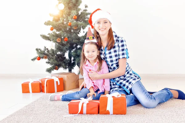 Concepto de Navidad, familia y vacaciones - Madre e hija festiva en casa en la sala de estar — Foto de Stock