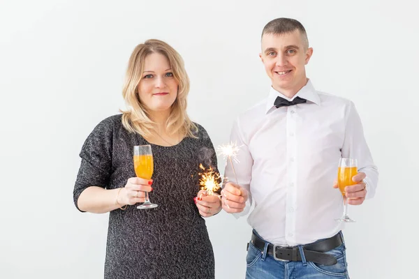 Vacaciones, Navidad, día de San Valentín y el concepto de año nuevo - Mujer y el hombre celebran y sostiene el vino en una copa sobre fondo blanco — Foto de Stock