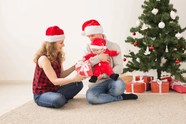 Счастливая пара с ребенком празднуют Рождество вместе дома . — стоковое фото