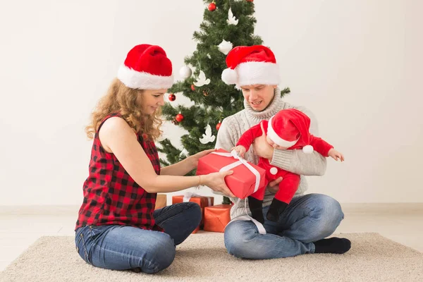 Szczęśliwa para z dzieckiem obchodzi Boże Narodzenie razem w domu. — Zdjęcie stockowe