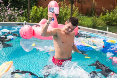 Ekoloji, plastik çöp, çevresel acil durum ve su kirliliği - kirli bir yüzme havuzunda duran şok adam