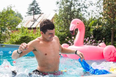 Ekoloji, plastik çöp, çevresel acil durum ve su kirliliği - kirli bir yüzme havuzunda duran şok adam