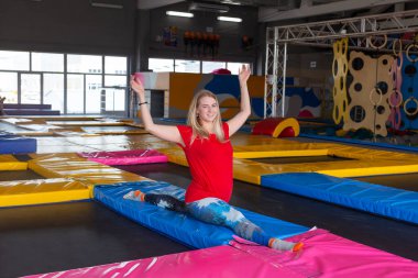 fitness, spor, egzersiz, germe ve insan kavramı - gülümseyen kadın spor salonu arka plan üzerinde mat üzerinde böler yapıyor