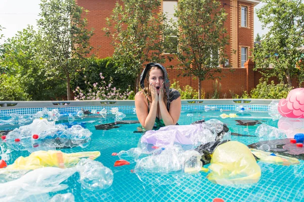 환경, 플라스틱 쓰레기, 환경 비상사태 및 수질 오염 - 불결 한 수영장에서 비닐봉지를 머리 위에 얹고 있는 여자 — 스톡 사진