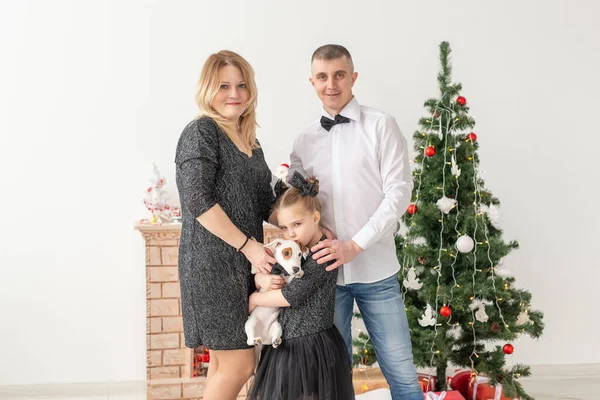 Conceito de feriados - família feliz mãe pai e filho na árvore de Natal em casa — Fotografia de Stock