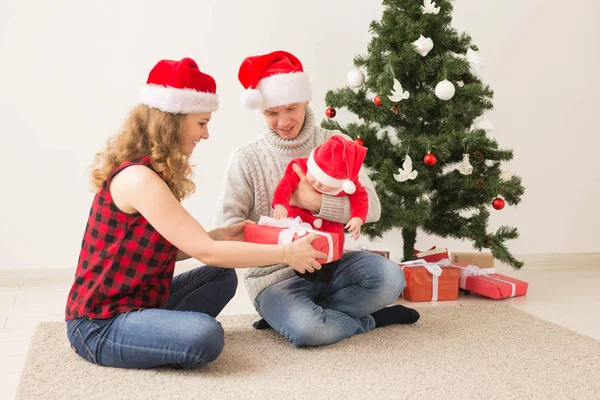 休日、子供と家族のコンセプト-自宅で一緒にクリスマスを祝う赤ちゃんを持つ幸せなカップル. — ストック写真