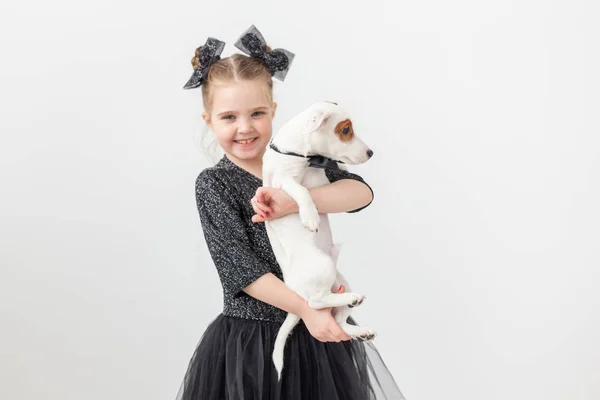 Husdjur och djur koncept - barn flicka som leker med valp Jack Russell Terrier. — Stockfoto