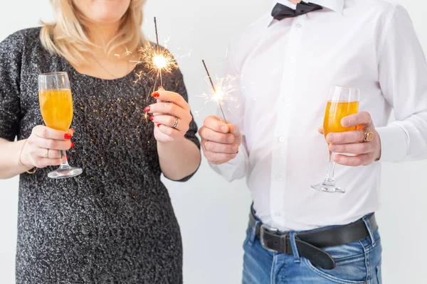 Feste, Natale, San Valentino e Capodanno - Donna e uomo celebrano e tengono il vino in un bicchiere su sfondo bianco — Foto Stock