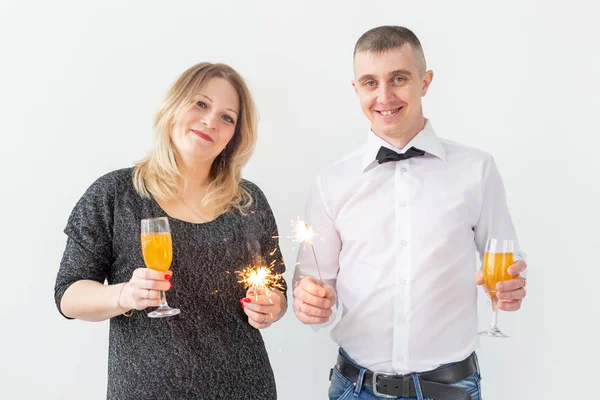 Vacaciones, Navidad, día de San Valentín y el concepto de año nuevo - Mujer y el hombre celebran y sostiene el vino en una copa sobre fondo blanco — Foto de Stock