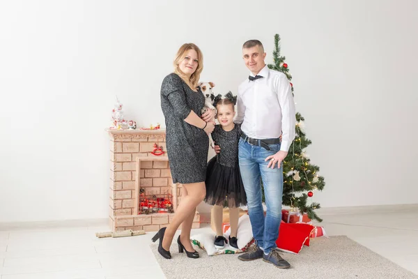 Conceito de feriados - família feliz mãe pai e filho na árvore de Natal em casa — Fotografia de Stock