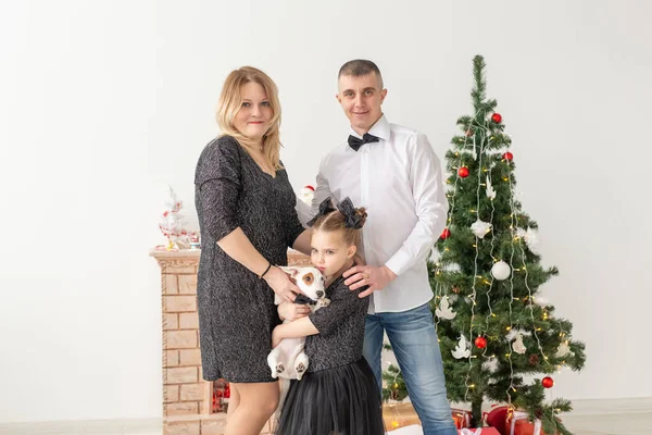 Conceito de feriados - família feliz mãe pai e filho na árvore de Natal em casa — Fotografia de Stock