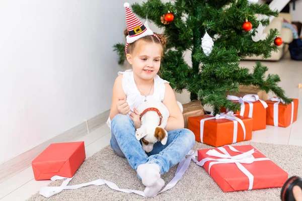 Χριστούγεννα, κατοικίδια ζώα και διακοπές έννοια - Παιδί σε καπέλο Σάντα με ένα Jack Russell τεριέ κουτάβι — Φωτογραφία Αρχείου
