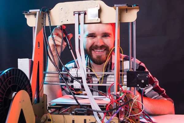 Teknoloji ve mühendislik konsepti - Laboratuvarda gece çalışan erkek mühendis, 3D yazıcı bileşenlerini ayarlıyor.