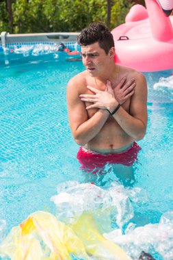 Ekoloji, plastik çöp, çevresel acil durum ve su kirliliği - kirli bir yüzme havuzunda duran şok adam