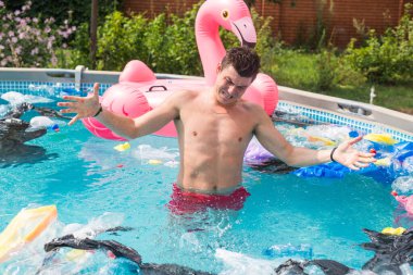 Ekoloji, plastik çöp, çevresel acil durum ve su kirliliği - kirli bir yüzme havuzunda duran şok adam