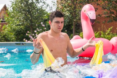 Ekoloji, plastik çöp, çevresel acil durum ve su kirliliği - kirli bir yüzme havuzunda duran şok adam