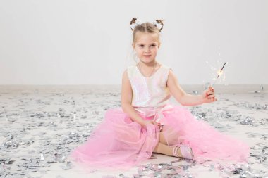 Tatiller, Noel, doğum günü partisi ve yeni yıl konsepti, elinde yanan maytap tutan çocuk. Komik bir partiden sonra.