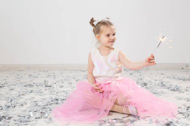 Tatiller, Noel, doğum günü partisi ve yeni yıl konsepti, elinde yanan maytap tutan çocuk. Komik bir partiden sonra.