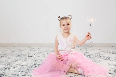 Tatiller, Noel, doğum günü partisi ve yeni yıl konsepti, elinde yanan maytap tutan çocuk. Komik bir partiden sonra.