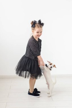 Evcil hayvan ve hayvan kavramı - Jack Russell Terrier köpekle oynayan kız çocuk.