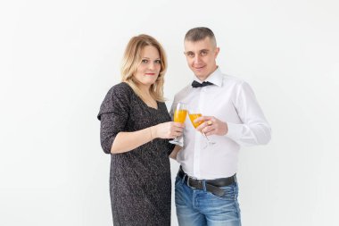 Tatiller, noeller, sevgililer günü ve yeni yıl konsepti - kadın ve erkek beyaz arka planda bir bardakta şarap içip kutluyor