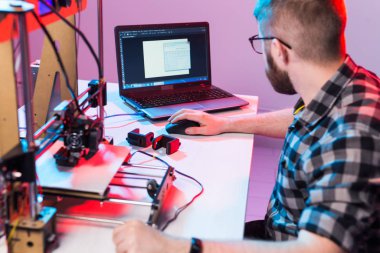 Teknoloji ve mühendislik konsepti - Laboratuvarda gece çalışan erkek mühendis, 3D yazıcı bileşenlerini ayarlıyor.