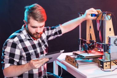 Teknoloji ve mühendislik konsepti - Laboratuvarda gece çalışan erkek mühendis, 3D yazıcı bileşenlerini ayarlıyor.