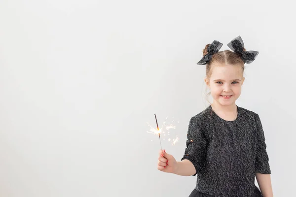 Semester, jul och nyårskoncept - Lyckligt barn håller brinnande tomtebloss i handen över vit bakgrund med kopieringsutrymme — Stockfoto